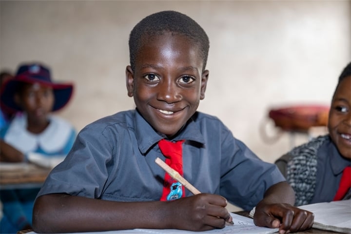 David smiling and studying at school after cleft surgery