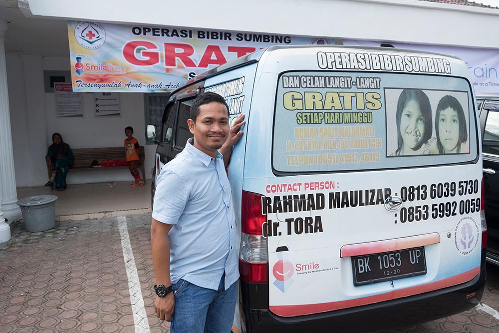 Aldan's social worker next to Smile Train van