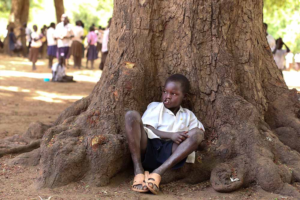 Kamse hides behind tree