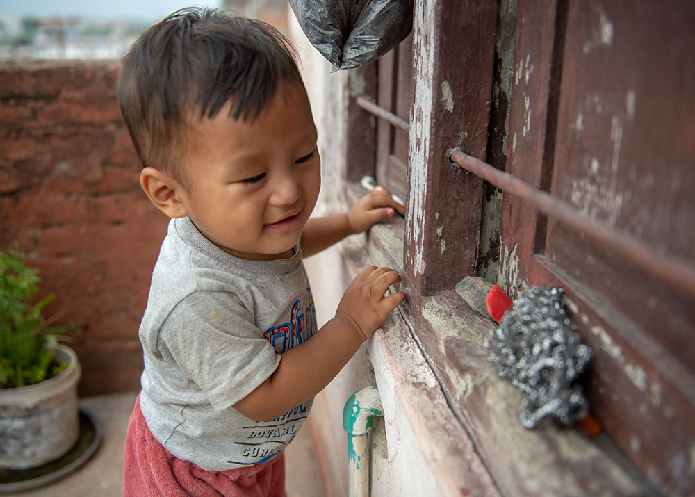 Smile stands against a wall