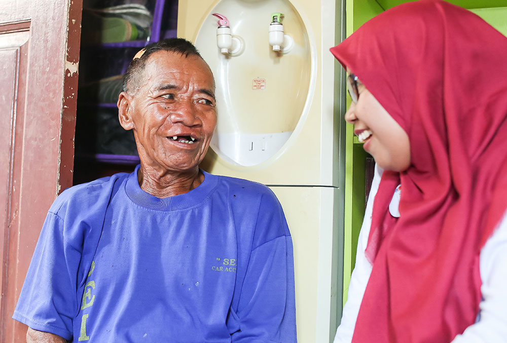 Endang speaks with an older Smile Train patient