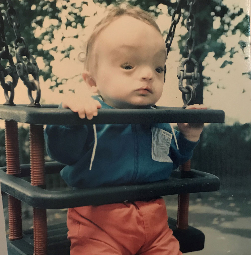 Christian Hadjipateras in a swing as a toddler