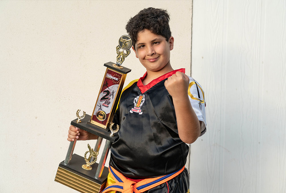 Juan holding a taekwondo trophy
