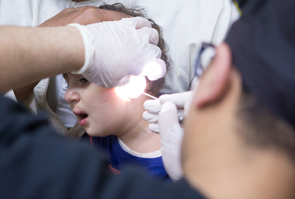 Dr Tarek examines a patient's ears