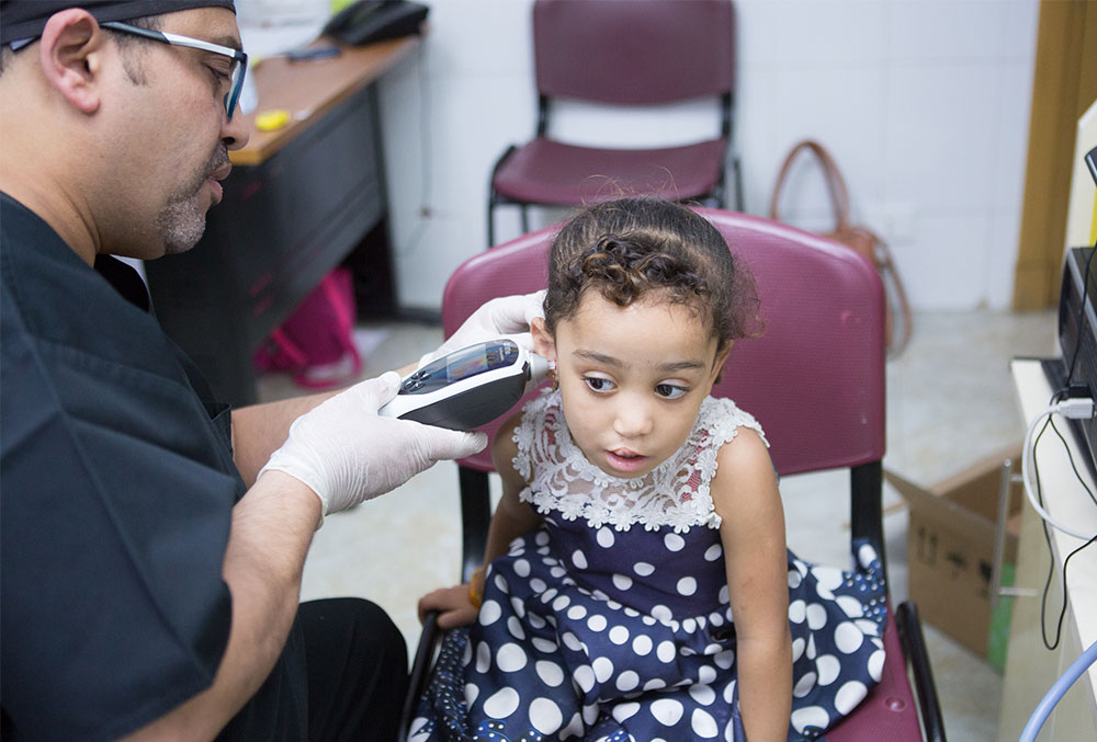Dr Tarek examining a patient's ears