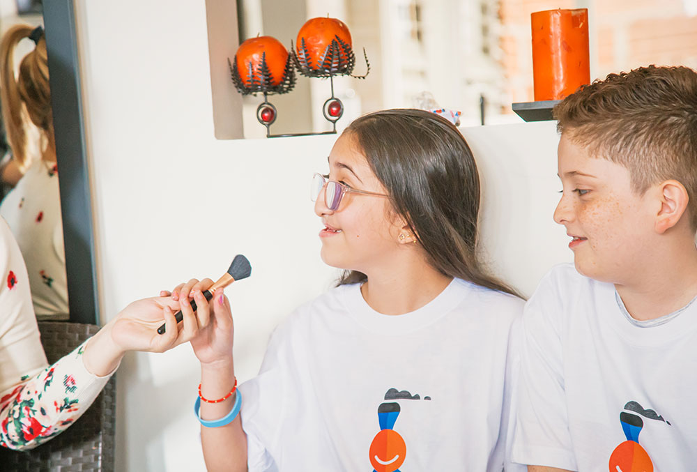 Diana hands Valery a make-up brush 