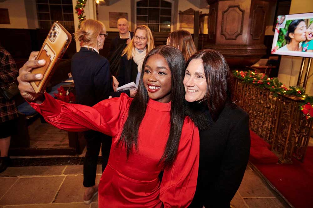 Susannah Schaefer smiling and taking a selfie with Miss Universe GB Noky Simbani
