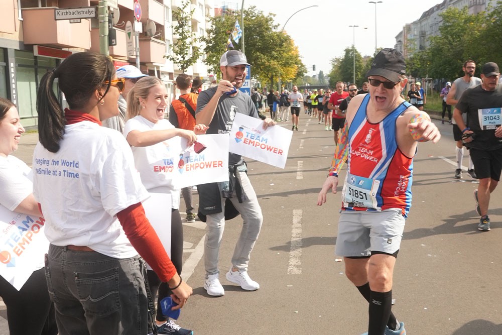 Smile Train’s cheer section in Berlin clapping on Team EMPOWER runner Geoff Jones
