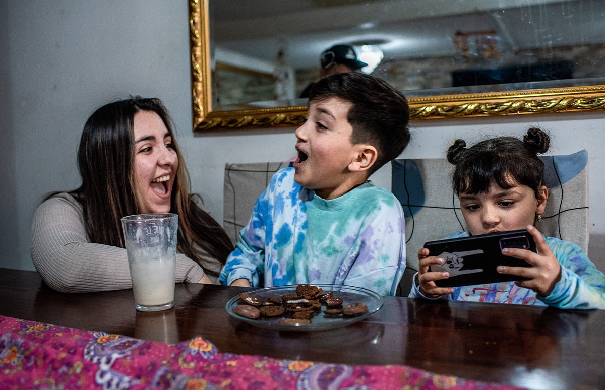 Joaquin and his mother share a laugh over biscuits and milk as Amanda plays on her phone