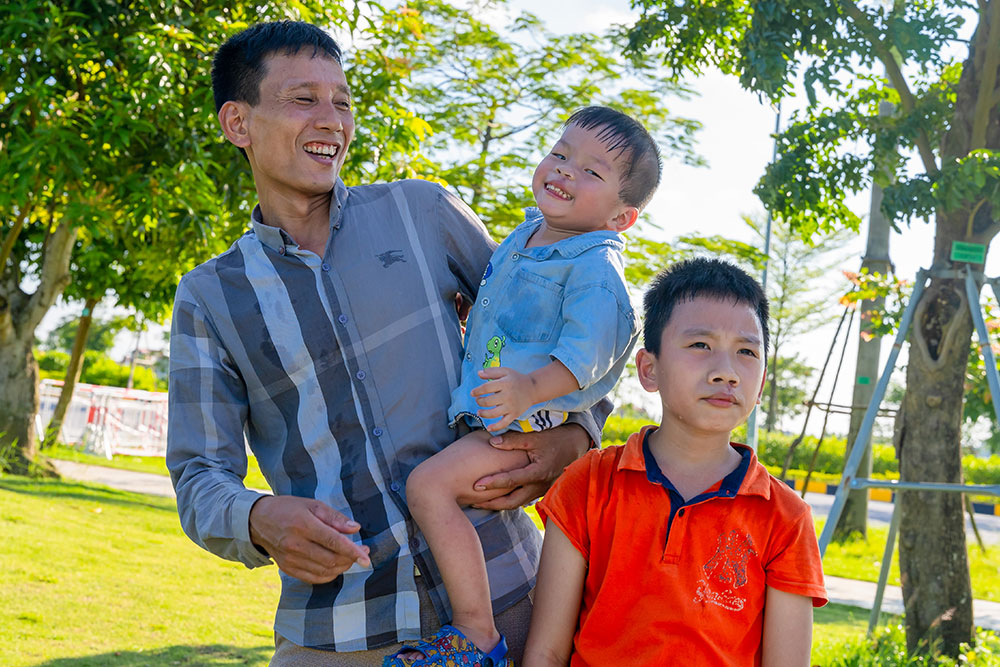 Dat, Quy, and their father, Xuan Son, share a smile after the boys’ cleft surgeries