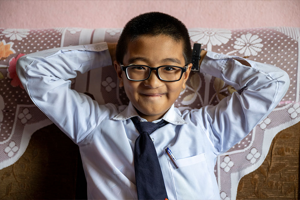 Close-up of Jenious smiling with his hands behind his head