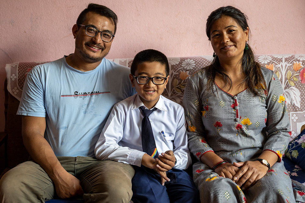 Jenious flanked by his parents on the family couch