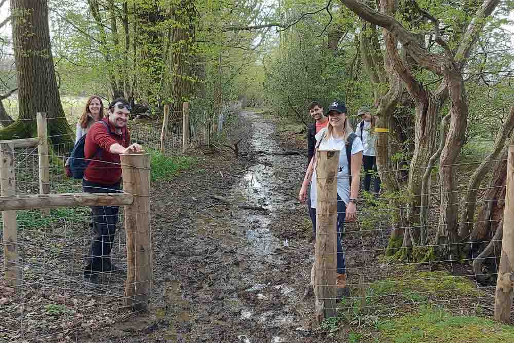 Members of DHA Planning hiking on a muddy path