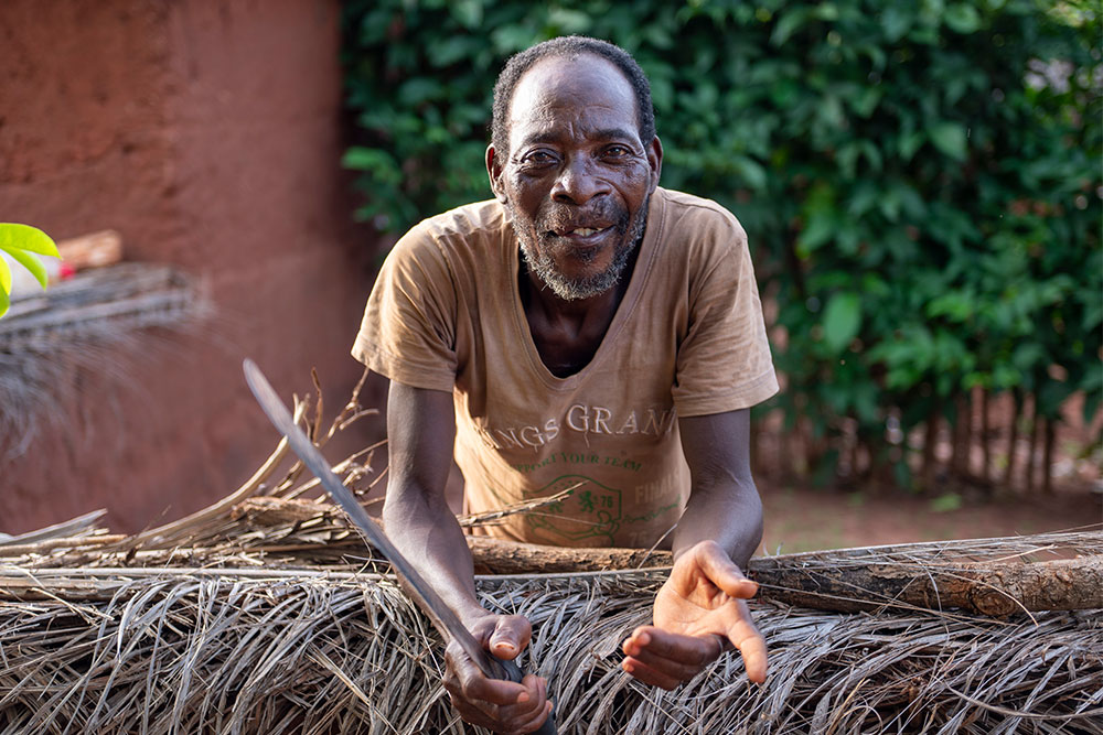 Edoh smiling, holding a machete for cutting fruit