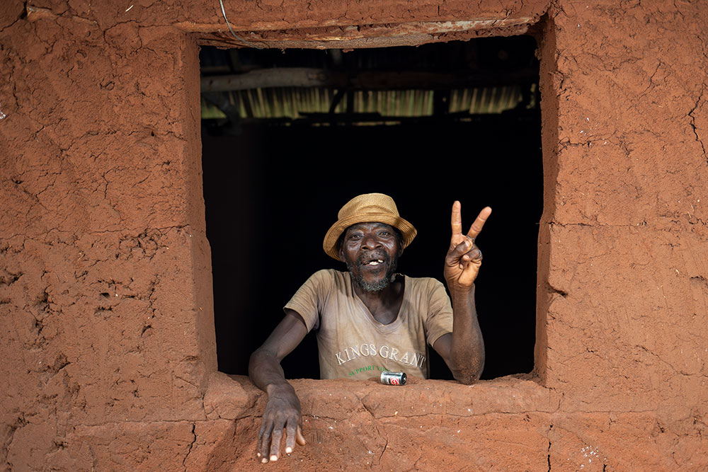 Edoh smiling, flashing a peace sign