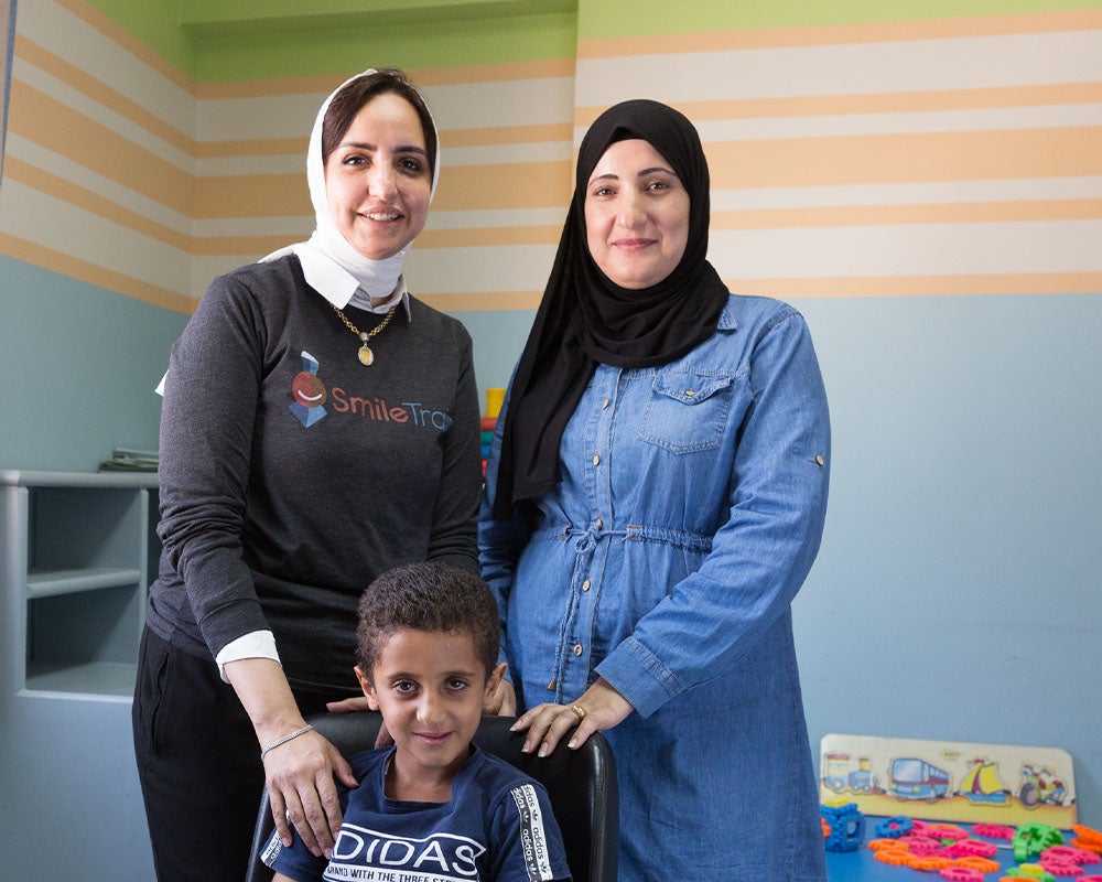 Fares sitting in front of Dr Sally Adel and Nadia, all smiling