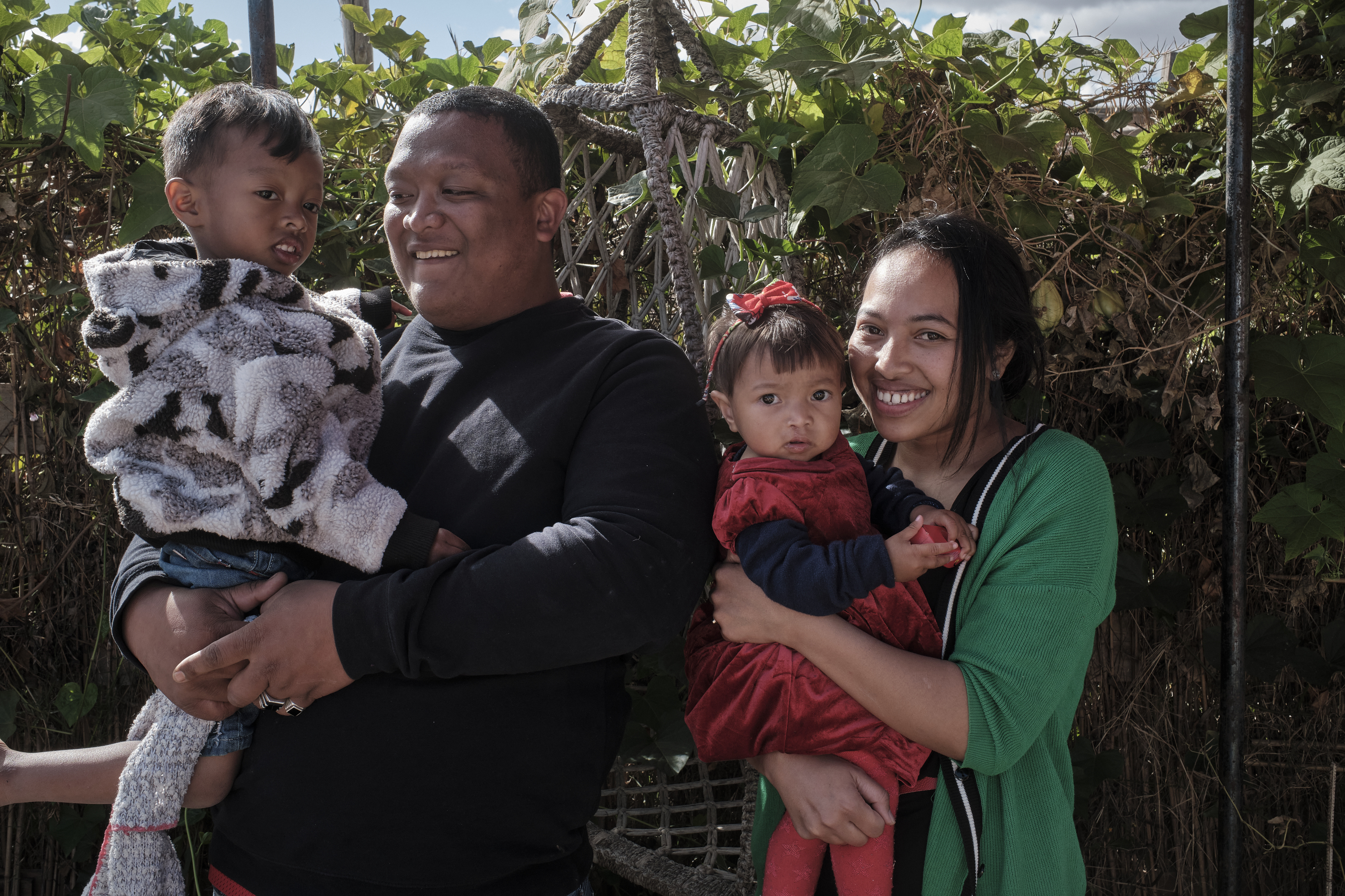 Sylvie and Andry smiling and holding Fy and her brother