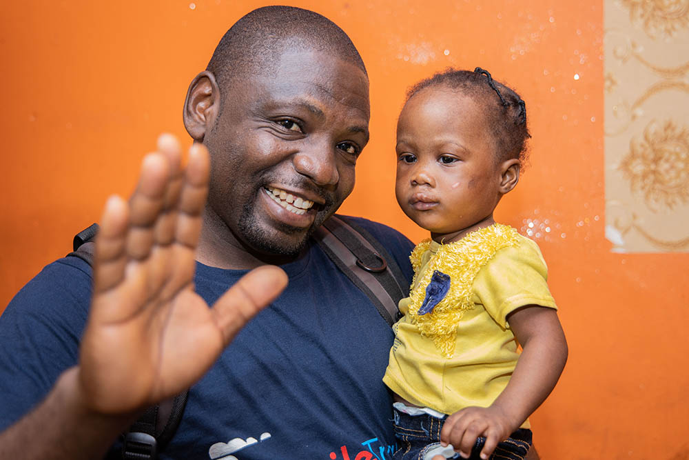 Paul Lobi smiling and holding one of the twins