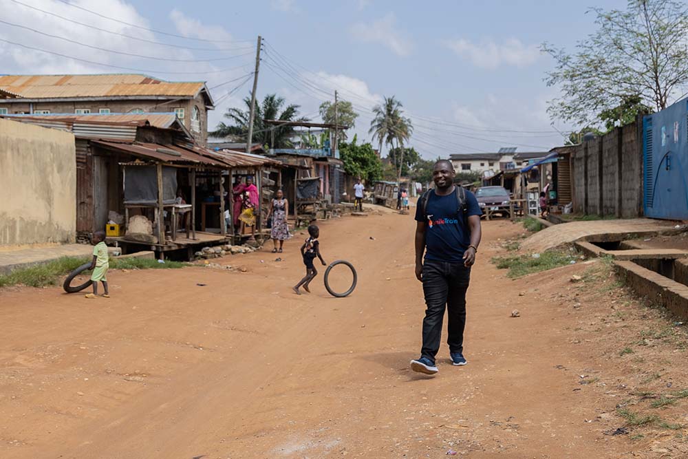 Paul Lobi smiling and walking down a street in Nigeria