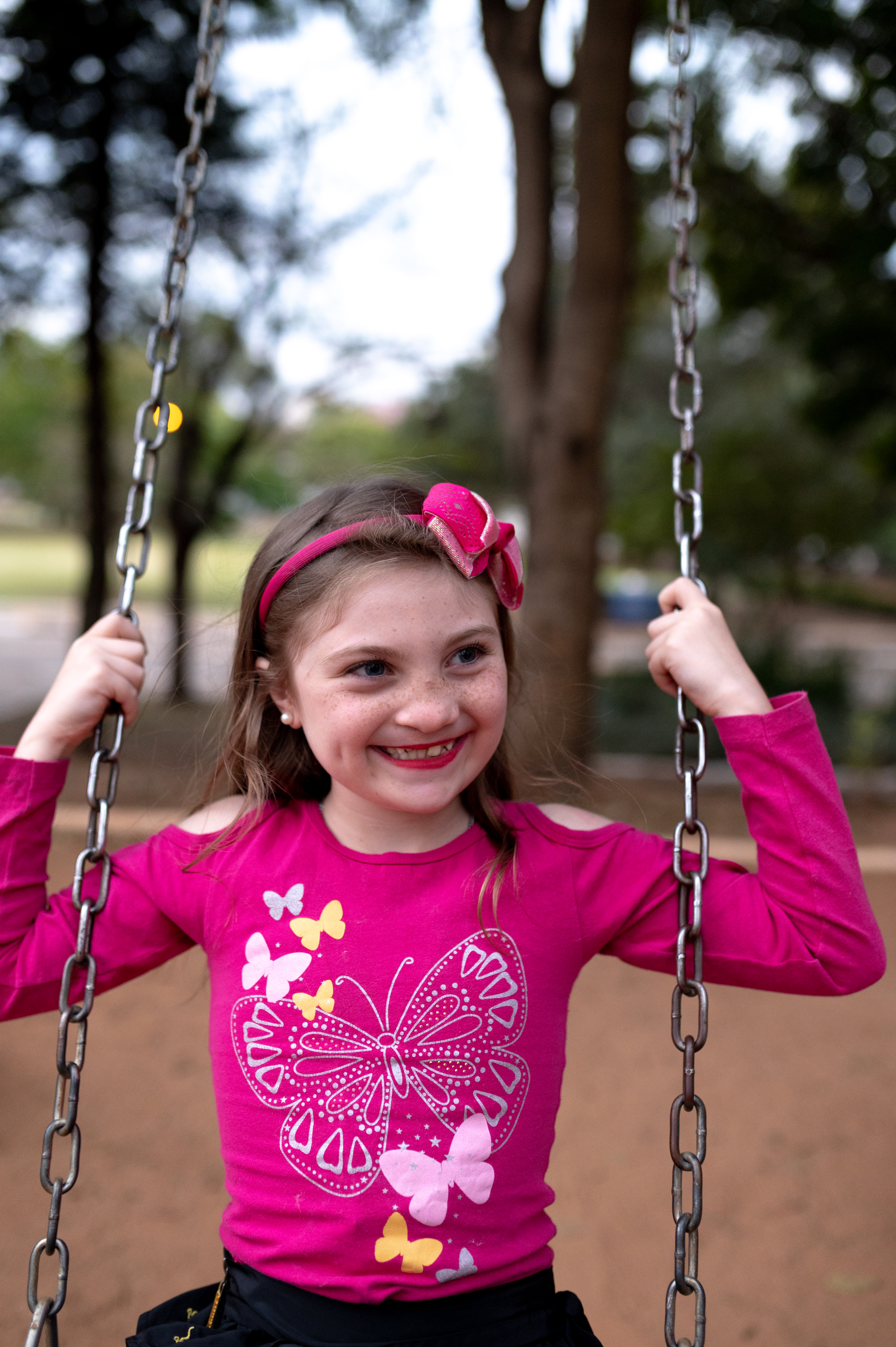 Milena sitting on a swing