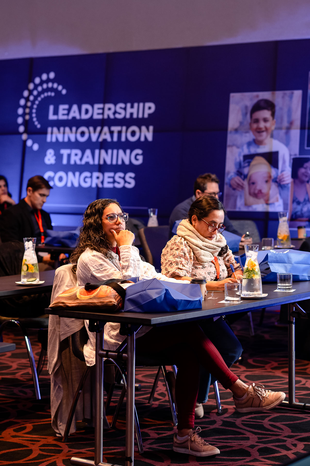 Two participants sitting at a conference table. Dr Jerem Cruz is taking notes while the Dr Lidia Tamayo is listening intently