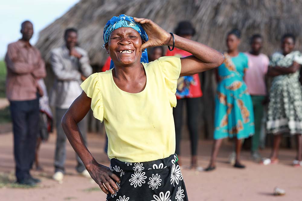 Zita posing for the camera with her family blurred in the background