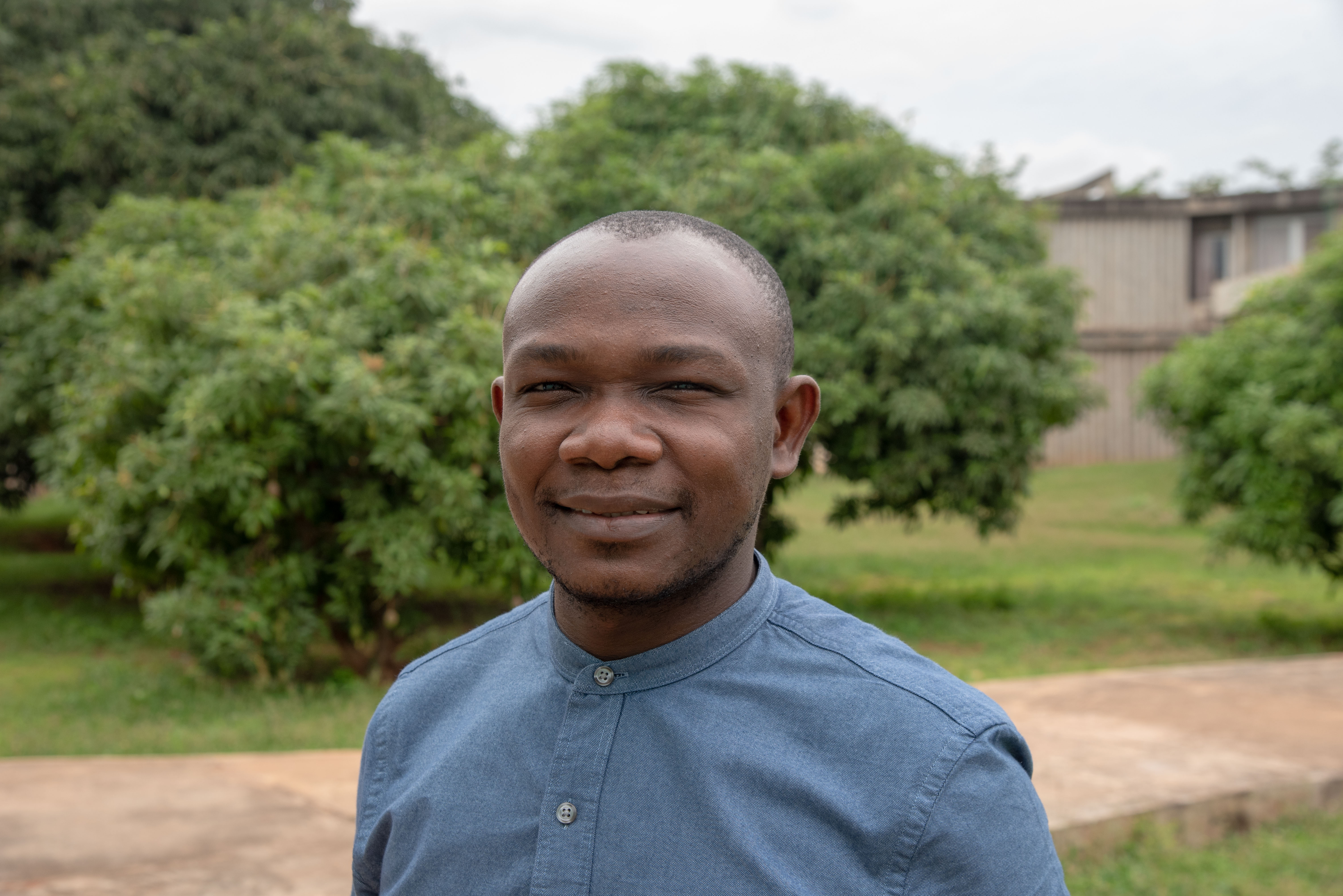 Edouardo smiling outside, chest-up