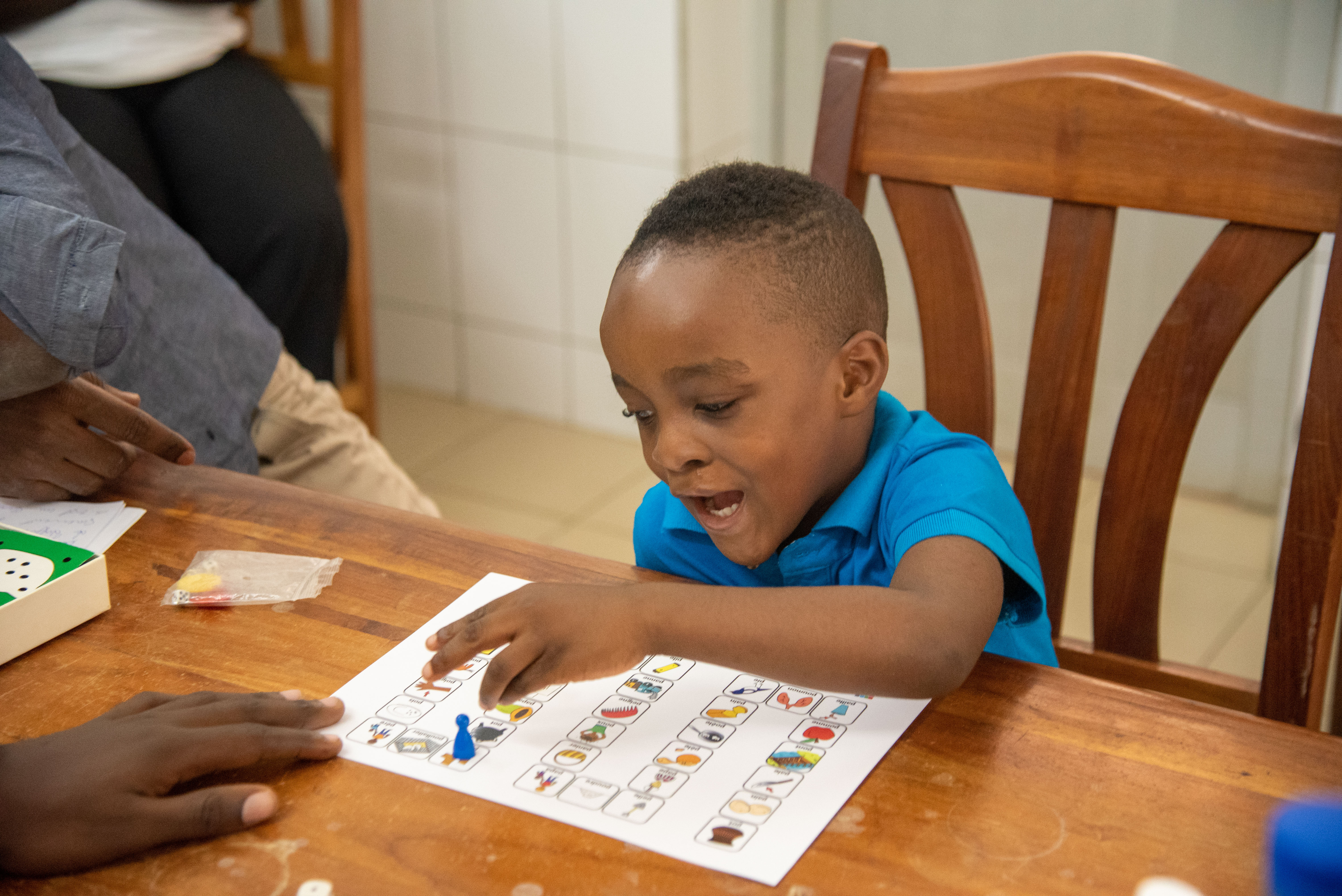 A young boy sitting and playing a speech therapy board game