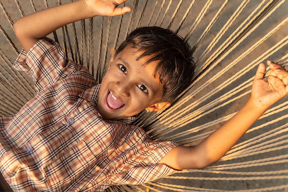 Manthan laying in a hammock, smiling widely