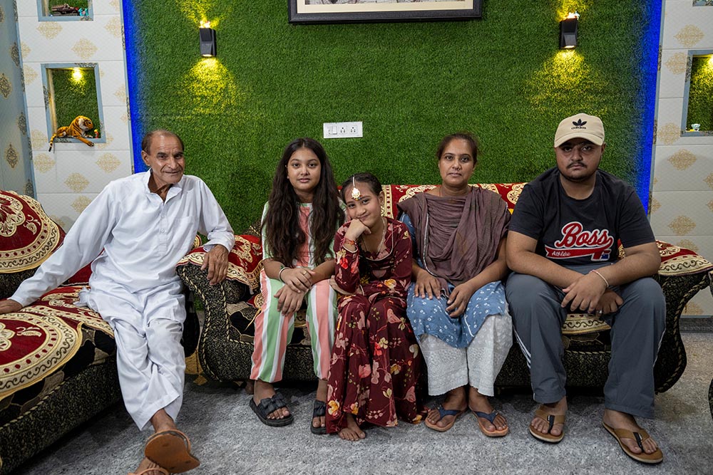 Bhumika smiling and sitting with her grandfather, sister, mother Jyoti and brother after her cleft surgery