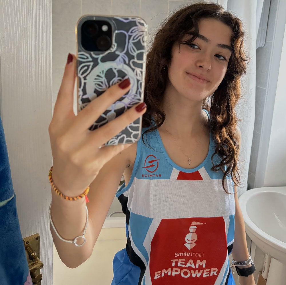 Georgina taking a selfie in her Team EMPOWER singlet in the bathroom mirror