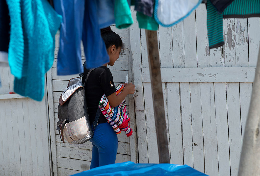 Zindia tying the plastic bag that she used to lock her house