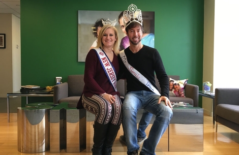 Troy Reinhart wears a crown next to a pageant winner at Smile Train's old offices