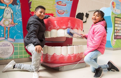 Alex and Kendra demonstrate tooth brushing technique on a giant mouth