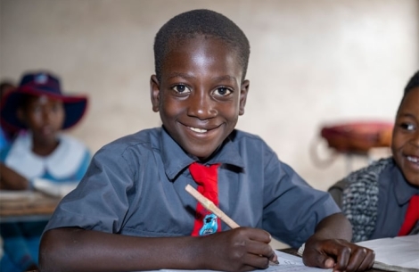 David smiling and studying at school after cleft surgery