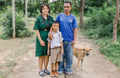 Aitya, Anuwat, and Chaipishek smiling with their dog
