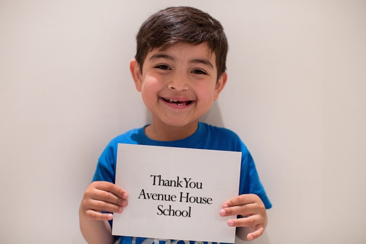 Boy holds a thank you sign to Avenue House School