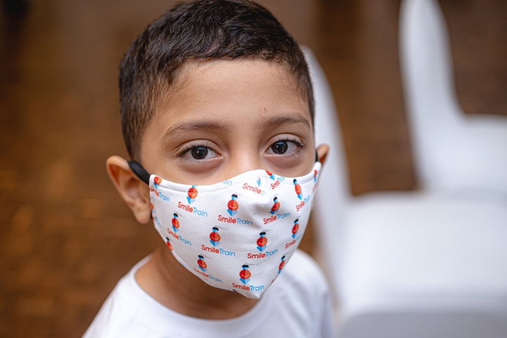 Boy from Colombia wears Smile Train branded mask