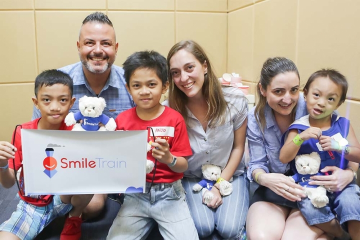 group of smile train supporters poses with patients in Asia