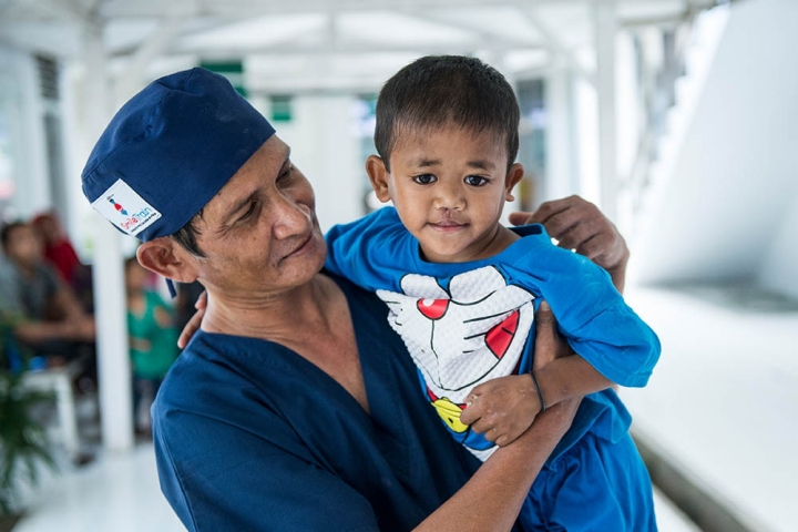 A Smile Train surgeon from Indonesia lifts a patient