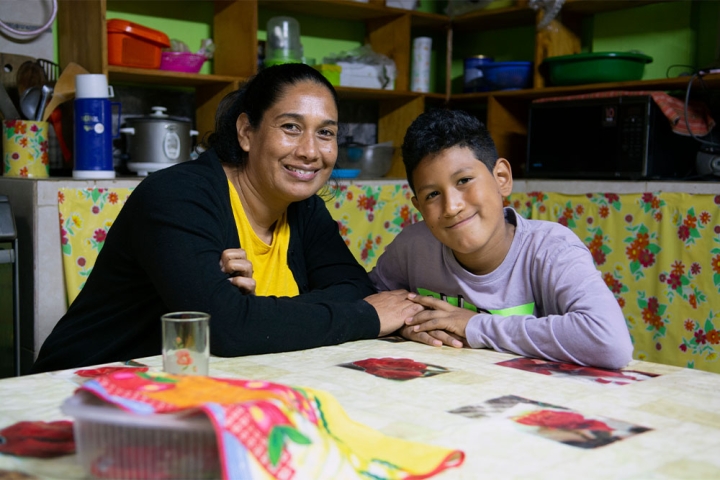 Carolina and Imanol sitting at the kitchen table holding hands