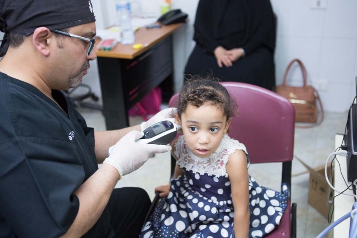 Smile Train partner using a hearing monitor on a cleft-affected patient