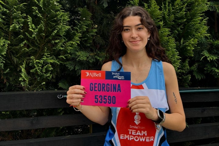 Georgina standing in her Team EMPOWER singlet in front of trees