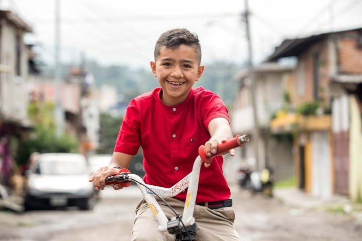 Jesus smiles and poses on his bike