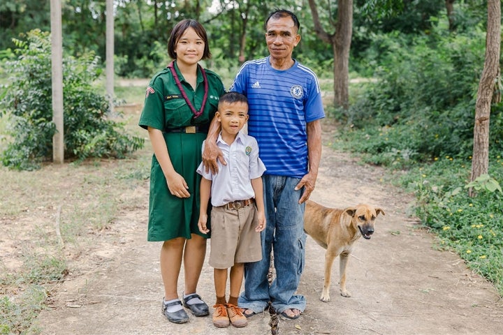 Aitya, Anuwat, and Chaipishek smiling with their dog