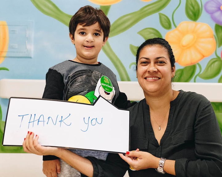 boy and mother hold a thank you sign