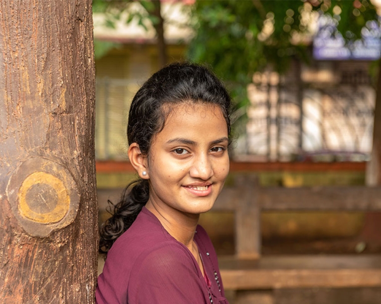 Bhargavi standing beneath a tree, smiling