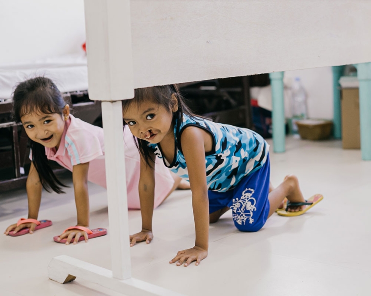 Ernie and Ermalen crawling together on the hospital floor before their cleft surgeries