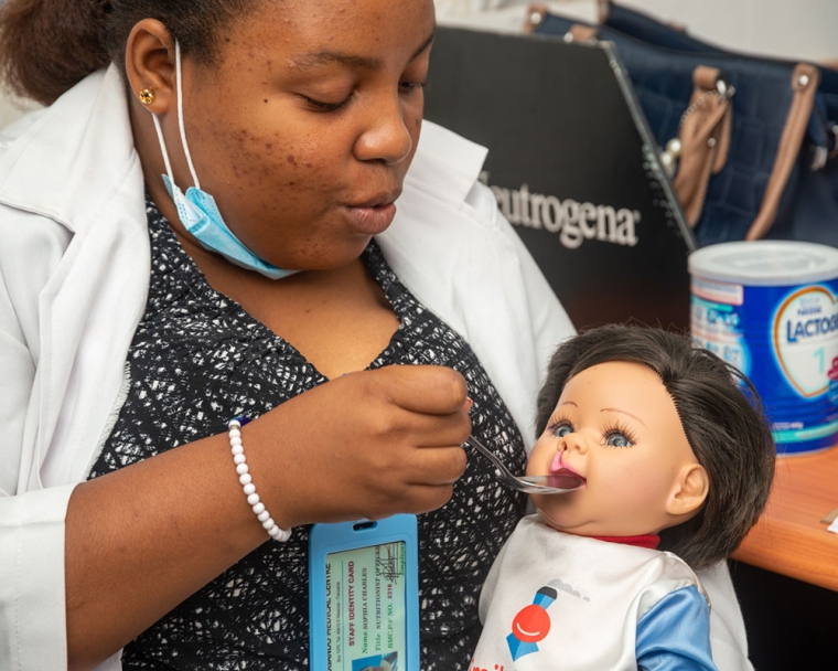 Sophia Charles gives a nutrition demonstration on a cleft doll