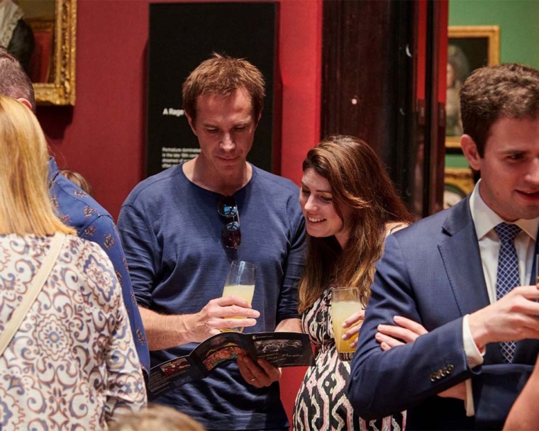 Actor James D’Aarcy looking at the Smile Train Summer Reception brochure